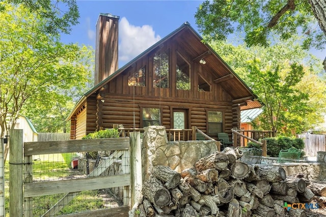 2662 Edgegrove, Canyon Lake, TX 78133 - rear view of house with log exterior and a chimney
