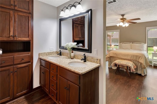 112 Laramie Dr, Victoria, TX 77904 - ensuite bathroom with wood finished floors, double vanity, a textured ceiling, and ceiling fan