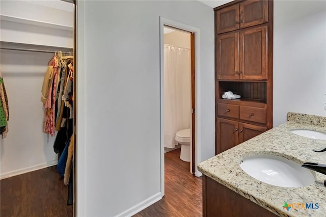 112 Laramie Dr, Victoria, TX 77904 - bathroom featuring wood finished floors, double vanity, a walk in closet, and curtained shower