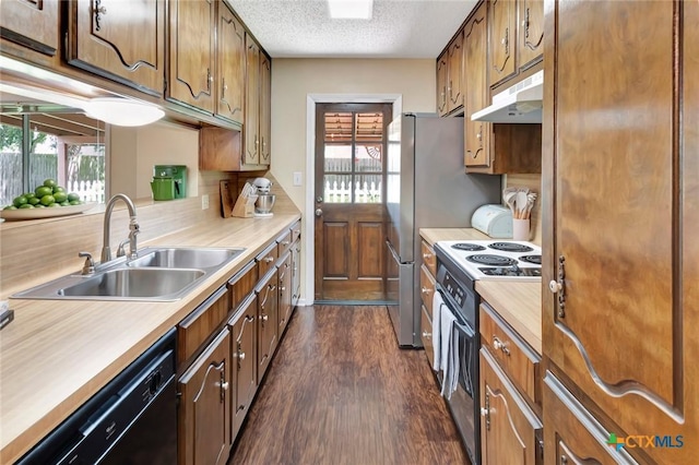 112 Laramie Dr, Victoria, TX 77904 - kitchen featuring black appliances, under cabinet range hood, dark wood finished floors, plenty of natural light, and a textured ceiling