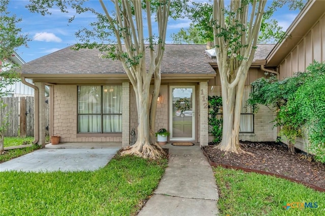 112 Laramie Dr, Victoria, TX 77904 - entrance to property with roof with shingles, board and batten siding, and brick siding