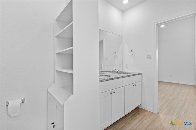 9063 Rancher Trl, Seguin, TX 78155 - bathroom featuring wood finished floors, double vanity, baseboards, and recessed lighting