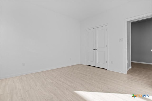 9063 Rancher Trl, Seguin, TX 78155 - unfurnished bedroom featuring light wood finished floors, baseboards, and a closet