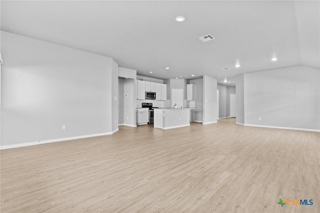 9063 Rancher Trl, Seguin, TX 78155 - unfurnished living room featuring baseboards, light wood-style floors, and recessed lighting