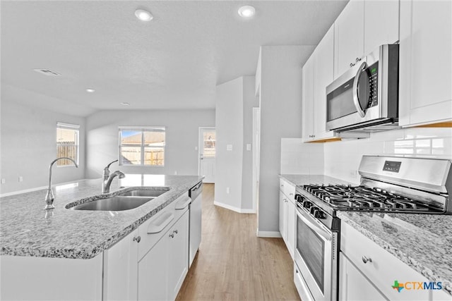 9063 Rancher Trl, Seguin, TX 78155 - kitchen with appliances with stainless steel finishes, a sink, white cabinetry, light stone counters, and recessed lighting