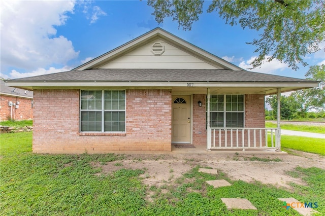 1012 N Beal St, Belton, TX 76513 - view of front of property featuring a porch, a front yard, roof with shingles, and brick siding