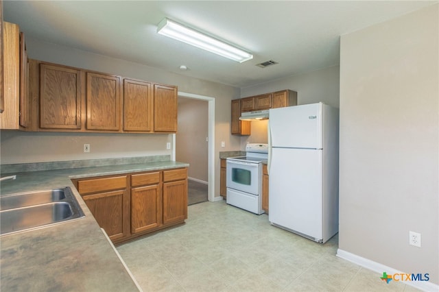 1012 N Beal St, Belton, TX 76513 - kitchen featuring white appliances, brown cabinetry, under cabinet range hood, and light flooring