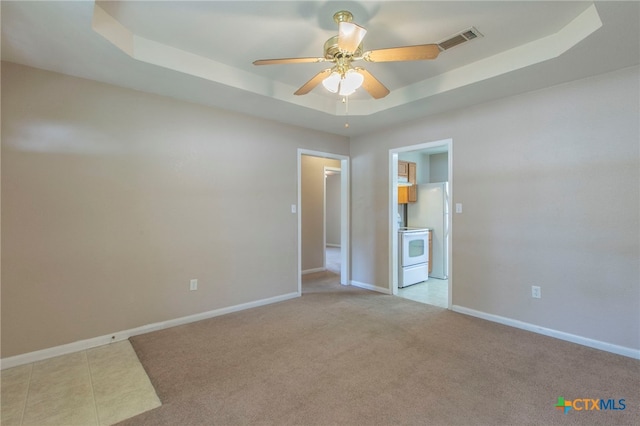 1012 N Beal St, Belton, TX 76513 - unfurnished bedroom featuring a tray ceiling, light carpet, freestanding refrigerator, and a ceiling fan