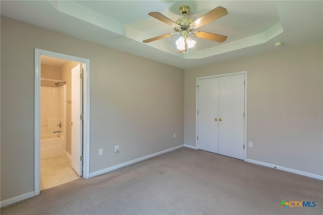 1012 N Beal St, Belton, TX 76513 - unfurnished bedroom with a raised ceiling, carpet flooring, connected bathroom, a closet, and a ceiling fan