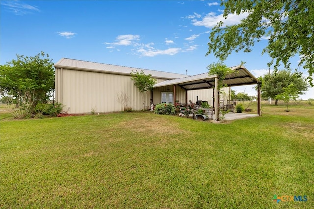 592 Dagg, Yoakum, TX 77995 - rear view of house featuring a yard, a metal roof, and an outbuilding