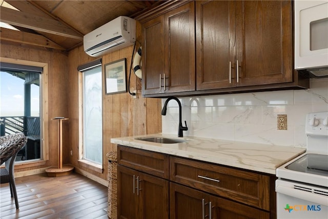 616 N Shore Dr, Port Mansfield, TX 78598 - kitchen with a sink, an AC wall unit, white appliances, wood finished floors, and decorative backsplash