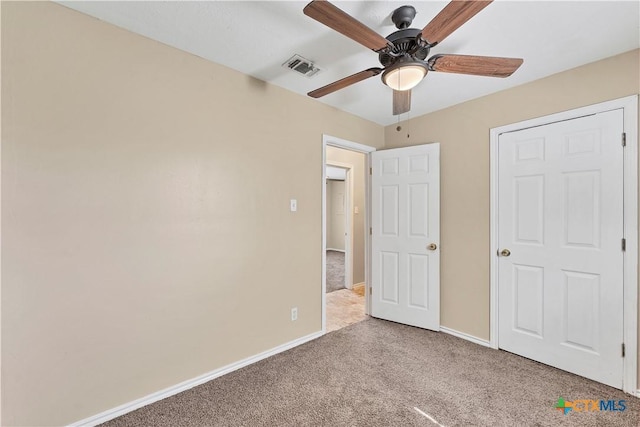 unfurnished bedroom with a ceiling fan, visible vents, carpet, and baseboards