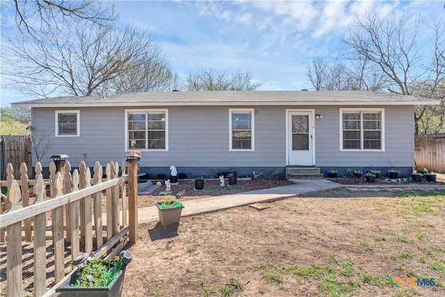 view of front of property with a garden, entry steps, and fence