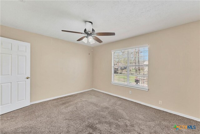 spare room with a textured ceiling, a ceiling fan, baseboards, and carpet floors