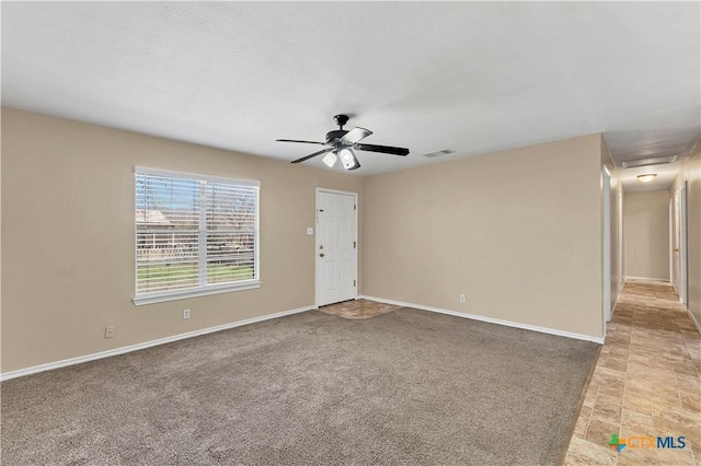 spare room featuring light colored carpet, baseboards, visible vents, and ceiling fan