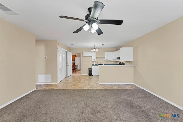 unfurnished living room featuring baseboards, visible vents, and light carpet