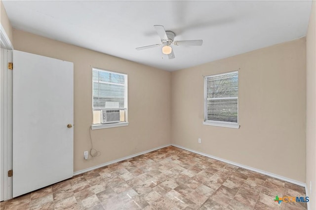 spare room with cooling unit, a ceiling fan, and baseboards