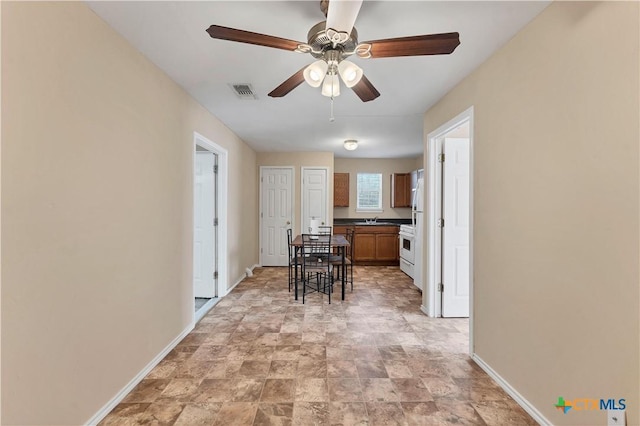 kitchen with visible vents, ceiling fan, white range with gas stovetop, and baseboards