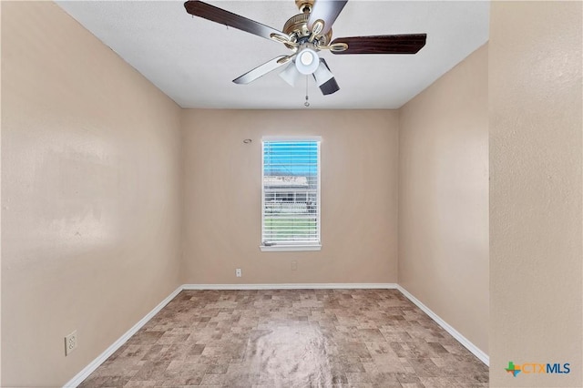 spare room with baseboards and ceiling fan