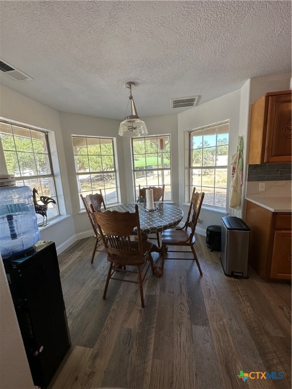 dining area with a healthy amount of sunlight, dark hardwood / wood-style flooring, and a chandelier