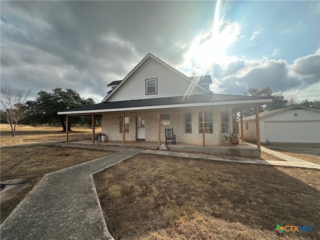 farmhouse-style home with covered porch, a garage, and an outdoor structure