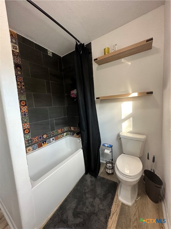 bathroom with toilet, a textured ceiling, hardwood / wood-style flooring, and shower / tub combo with curtain