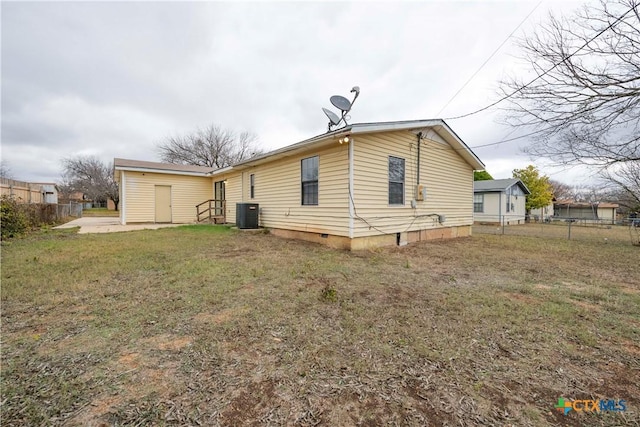 back of property with a yard and central AC unit