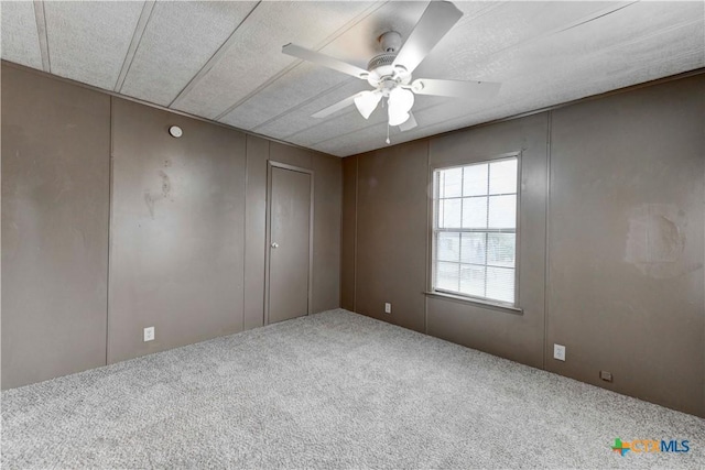 spare room featuring ceiling fan, carpet floors, and a textured ceiling