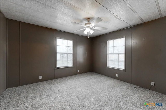 spare room featuring carpet, a textured ceiling, and ceiling fan