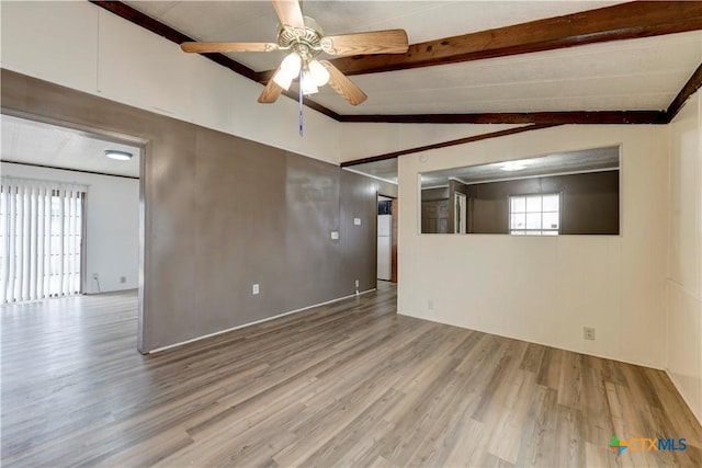 spare room with hardwood / wood-style floors, lofted ceiling with beams, and ceiling fan