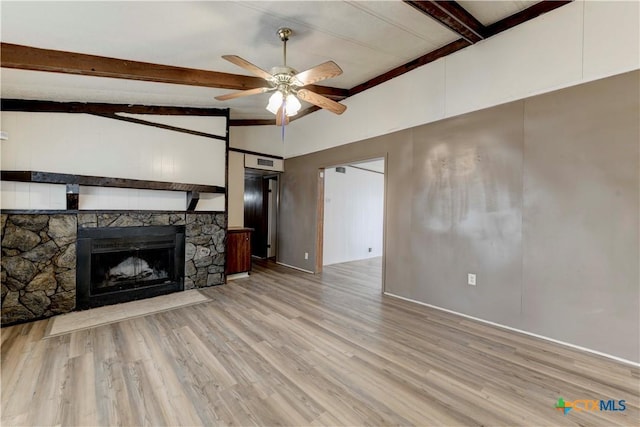 unfurnished living room featuring vaulted ceiling with beams, ceiling fan, a fireplace, and light hardwood / wood-style flooring