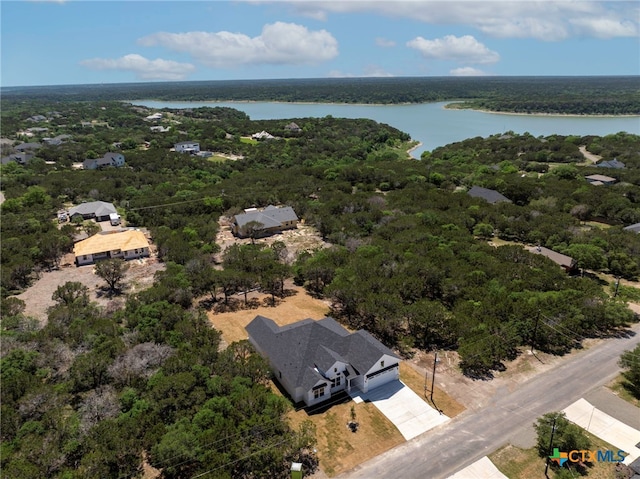 drone / aerial view featuring a forest view and a water view