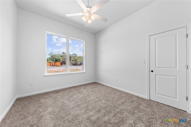 carpeted spare room featuring baseboards and ceiling fan