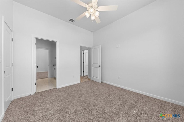 unfurnished bedroom with light carpet, visible vents, baseboards, ceiling fan, and ensuite bath