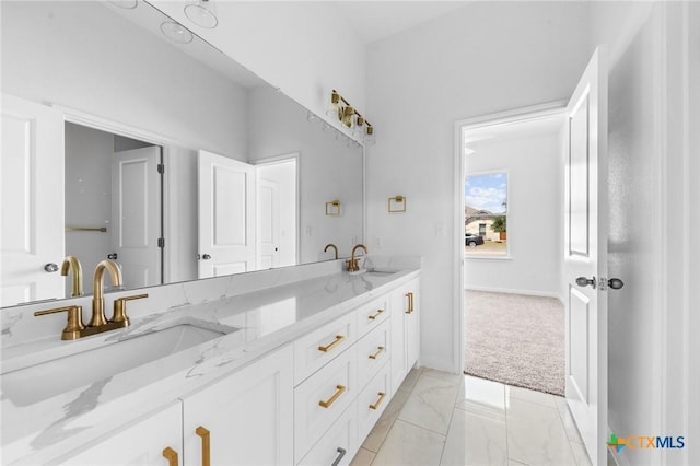 bathroom featuring double vanity, marble finish floor, and a sink