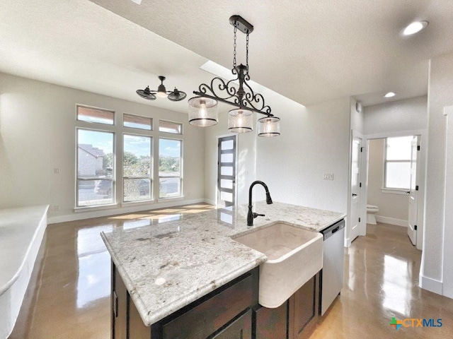 kitchen with a kitchen island with sink, a healthy amount of sunlight, decorative light fixtures, and light stone counters