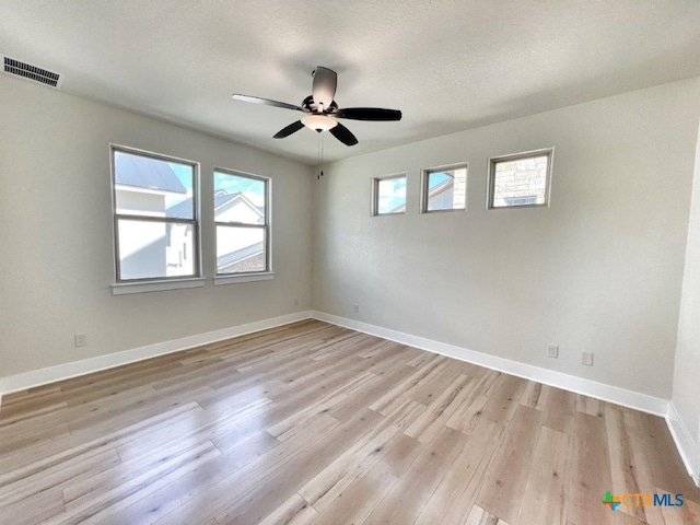 unfurnished room featuring light hardwood / wood-style floors, ceiling fan, and a textured ceiling