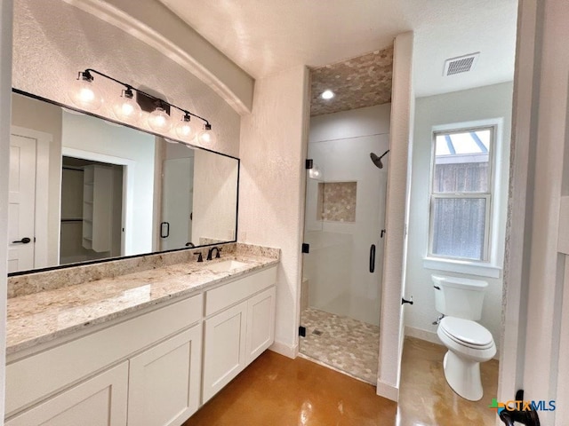 bathroom featuring walk in shower, vanity, and toilet