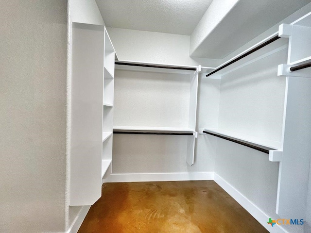 walk in closet with dark carpet