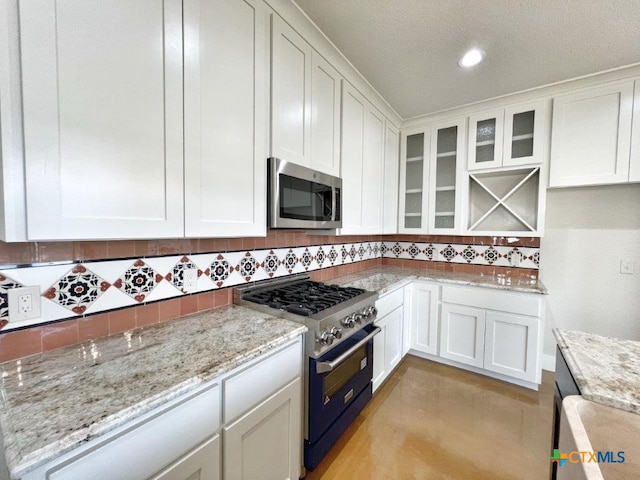 kitchen with white cabinets, stainless steel appliances, and tasteful backsplash