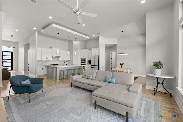 6310 Brasada Ln, Temple, TX 76502 - living area with a towering ceiling, a ceiling fan, recessed lighting, light wood-style flooring, and baseboards