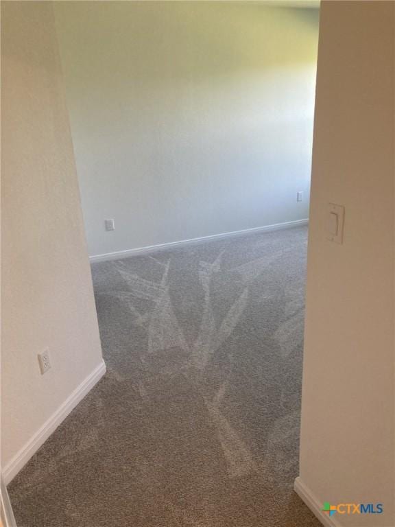 carpeted spare room with baseboards