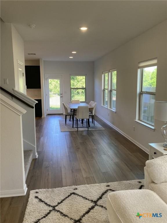 dining area with baseboards, recessed lighting, wood finished floors, and stairs