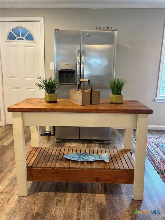 1403 Bill Tindall Ave, Seadrift, TX 77983 - detailed view of wood finished floors, ornamental molding, stainless steel refrigerator with ice dispenser, and baseboards