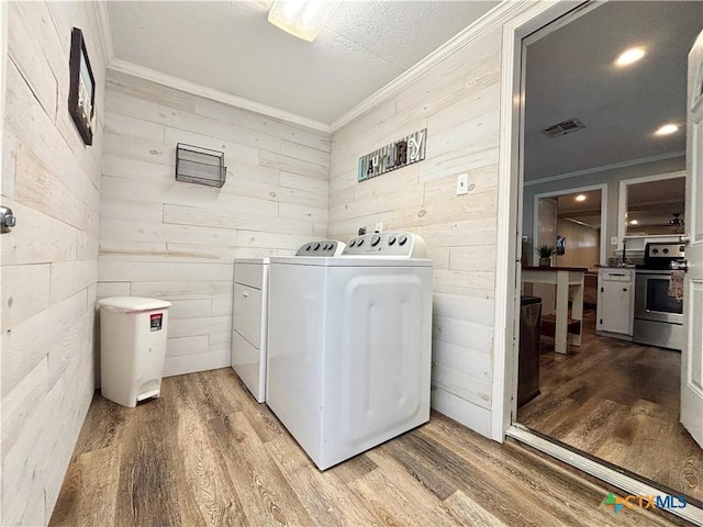 1403 Bill Tindall Ave, Seadrift, TX 77983 - clothes washing area with washer and dryer, crown molding, wood finished floors, and wooden walls