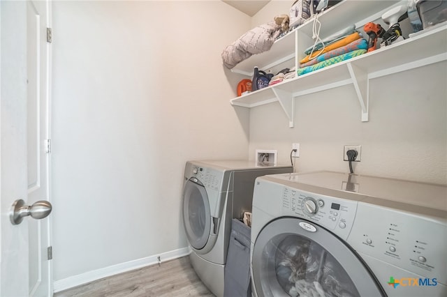 laundry room featuring washer and dryer and light hardwood / wood-style flooring