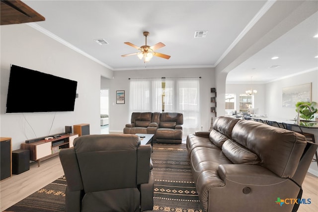 living room with ceiling fan with notable chandelier, light hardwood / wood-style flooring, and ornamental molding