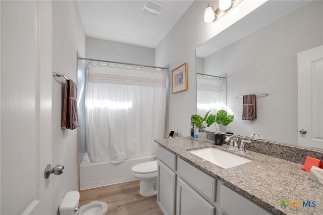 full bathroom with a healthy amount of sunlight, shower / bath combo with shower curtain, wood-type flooring, vanity, and toilet