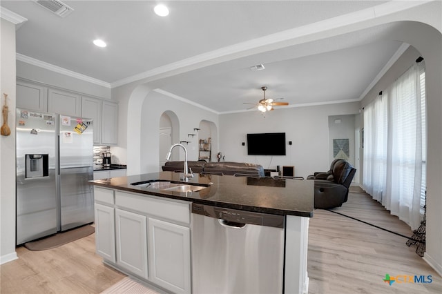 kitchen with light wood-type flooring, stainless steel appliances, sink, and an island with sink