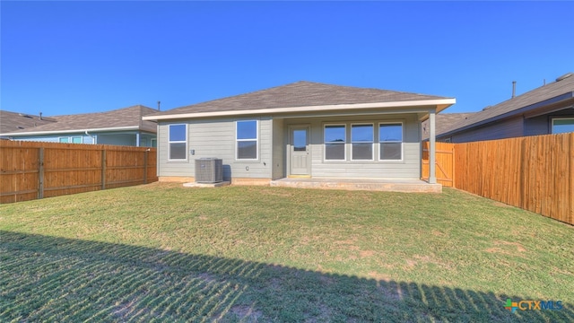 back of property featuring central air condition unit, a fenced backyard, and a yard